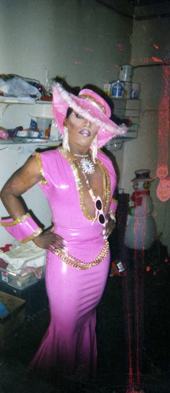 A feminine performer poses in matching pink attire backstage at Soakie's.