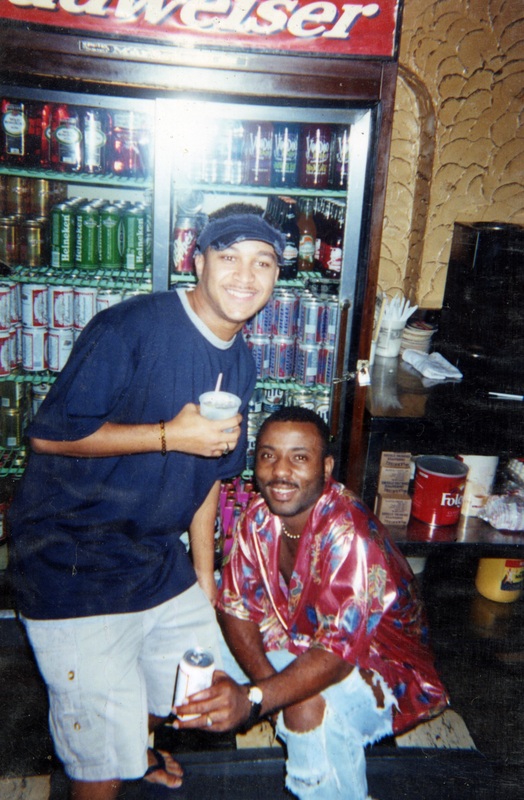 Danny Cashmere kneels to the right of his friend, Kermit, in front of a fridge at Soakie's.
