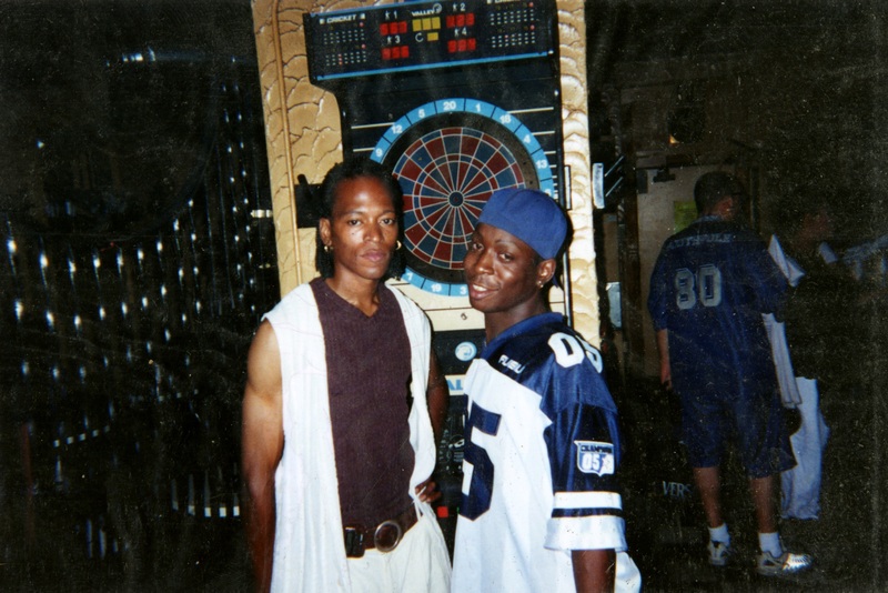 Two men pose in front of dart board at Soakie's.